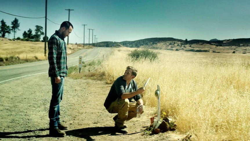 Still image of Aaron Moorhead and Justin Benson inspecting a roadside memorial from 2017 film The Endless.