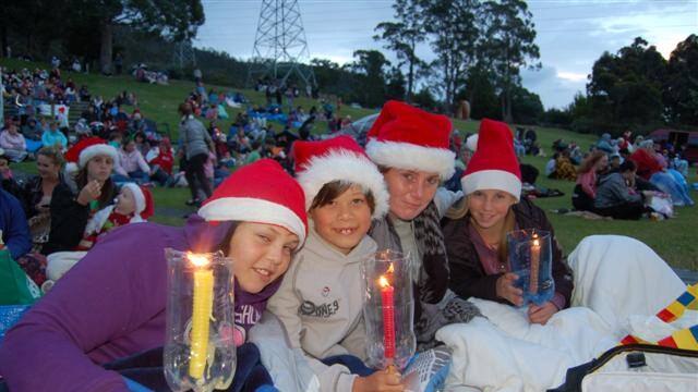 Children with lit candles wait for the Glenorchy carols to start.