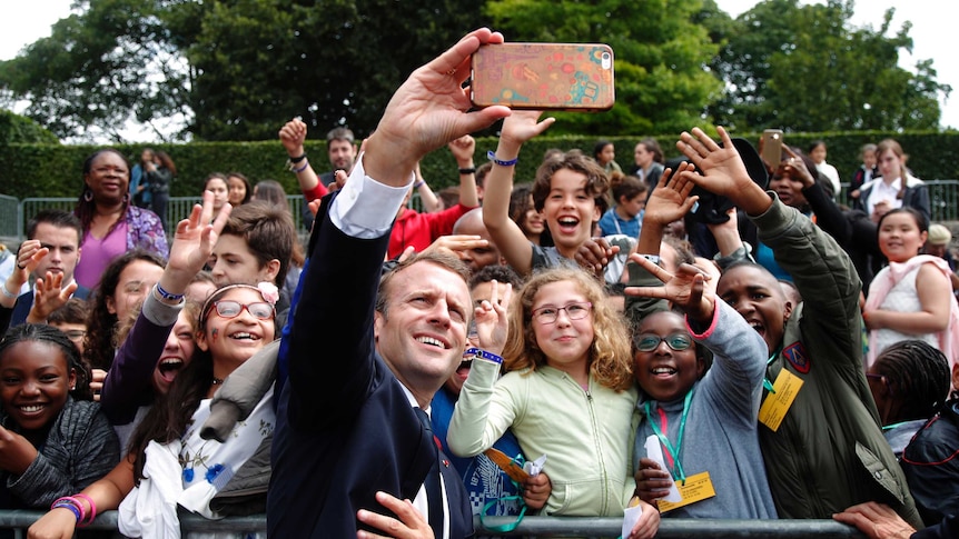 Macron takes selfie with group of boys and girls