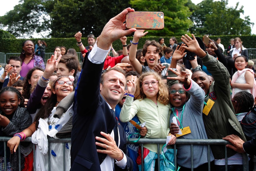 Macron takes selfie with group of boys and girls