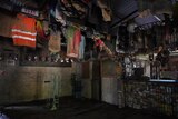A range of mud-covered shirts and other memorabilia hang on the wall next to a muddy bar.