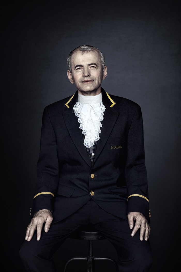 A portrait photograph of a New York City doormen in his uniform.