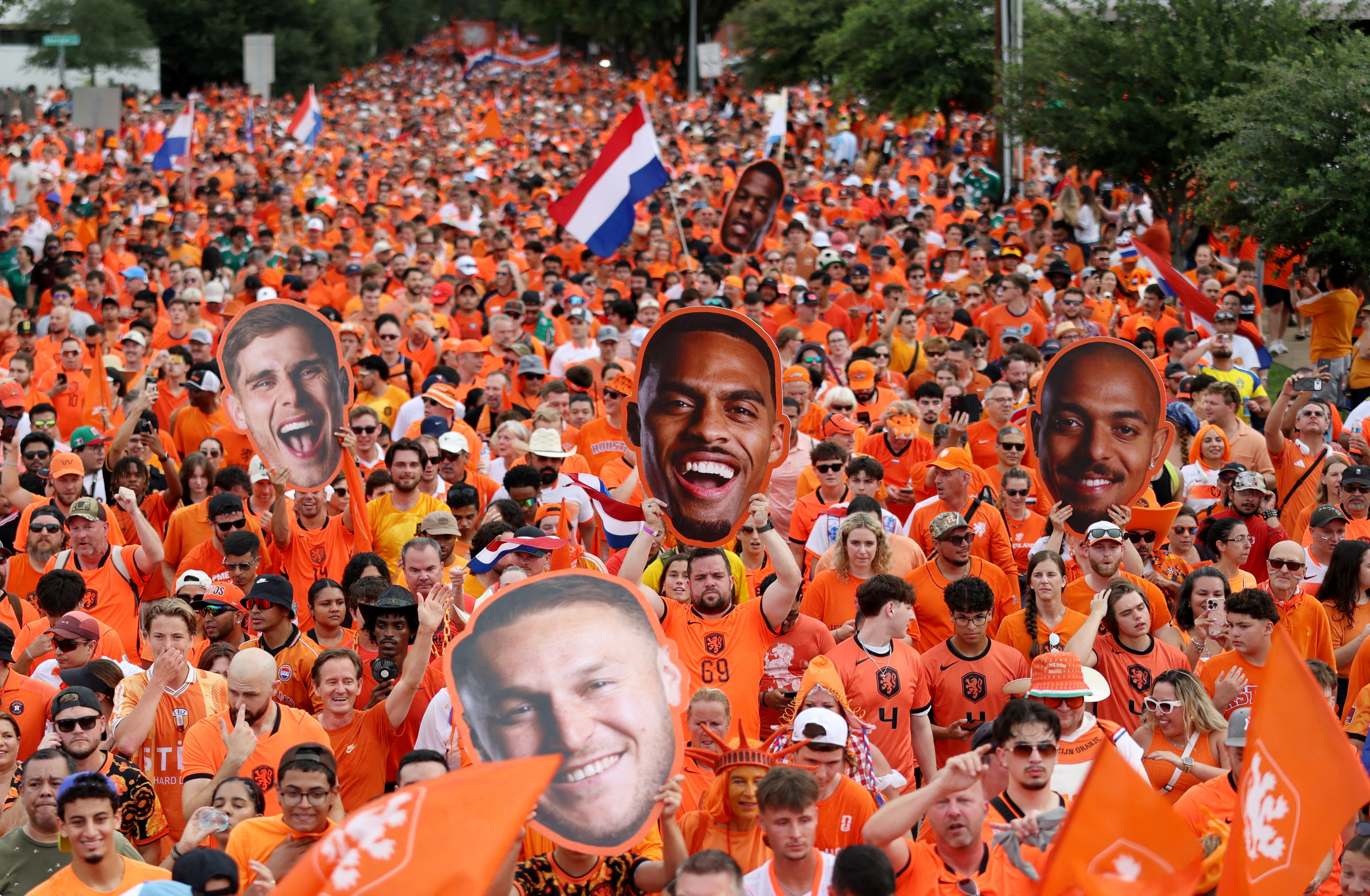 Netherlands fans in orange holding cardboard cut outs of players