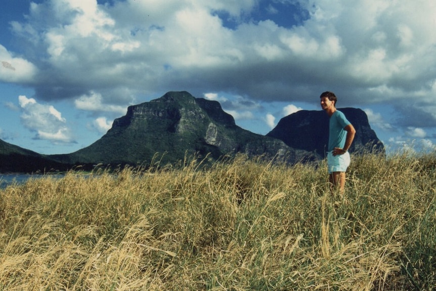 Lord Howe Island Chris Murray stands at Blackburn Isle looking over the island smiling.