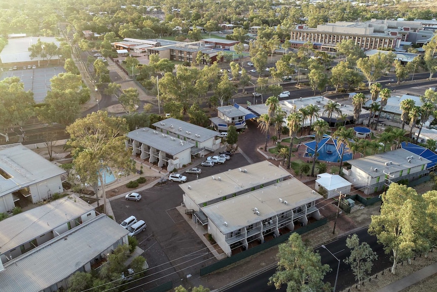 An aerial photograph of the Ibis Styles Hotel, with the sun setting and trees surrounding the building.