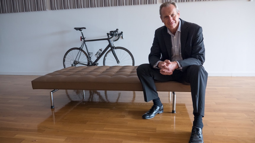 Supercycle founder Mark Day with his bicycle resting on the wall in the background.