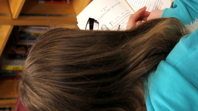 Unidentified child reading in a library