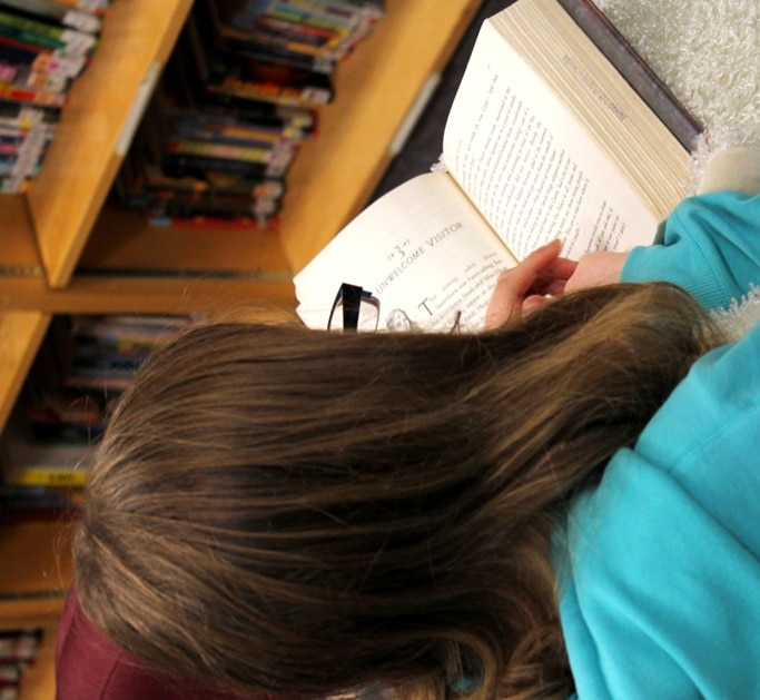 Unidentified child reading in a library