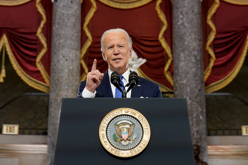 US President Joe Biden speaking at lectern.