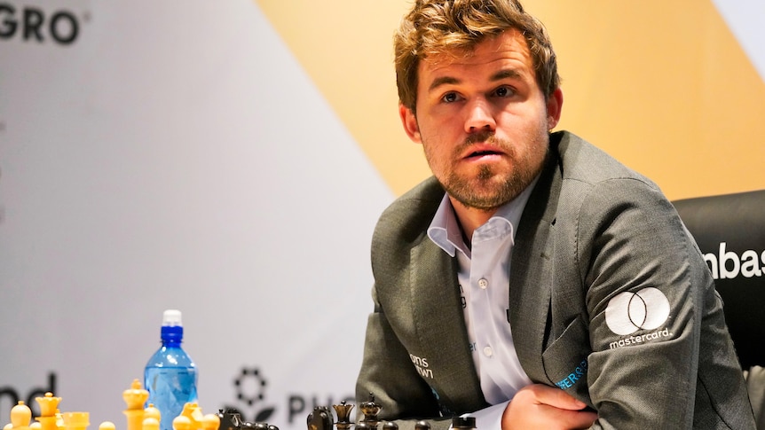 A chess grandmaster looks out from the stage as he sits at the board during the World Chess Championship.