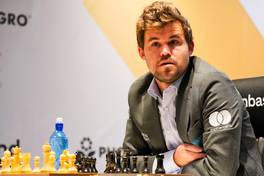 A chess grandmaster looks out from the stage as he sits at the board during the World Chess Championship.