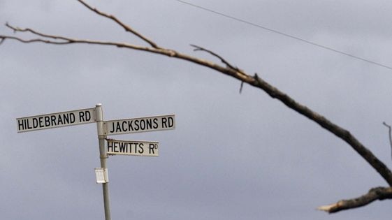 An Australian Federal policeman stands guard near the town of Kinglake