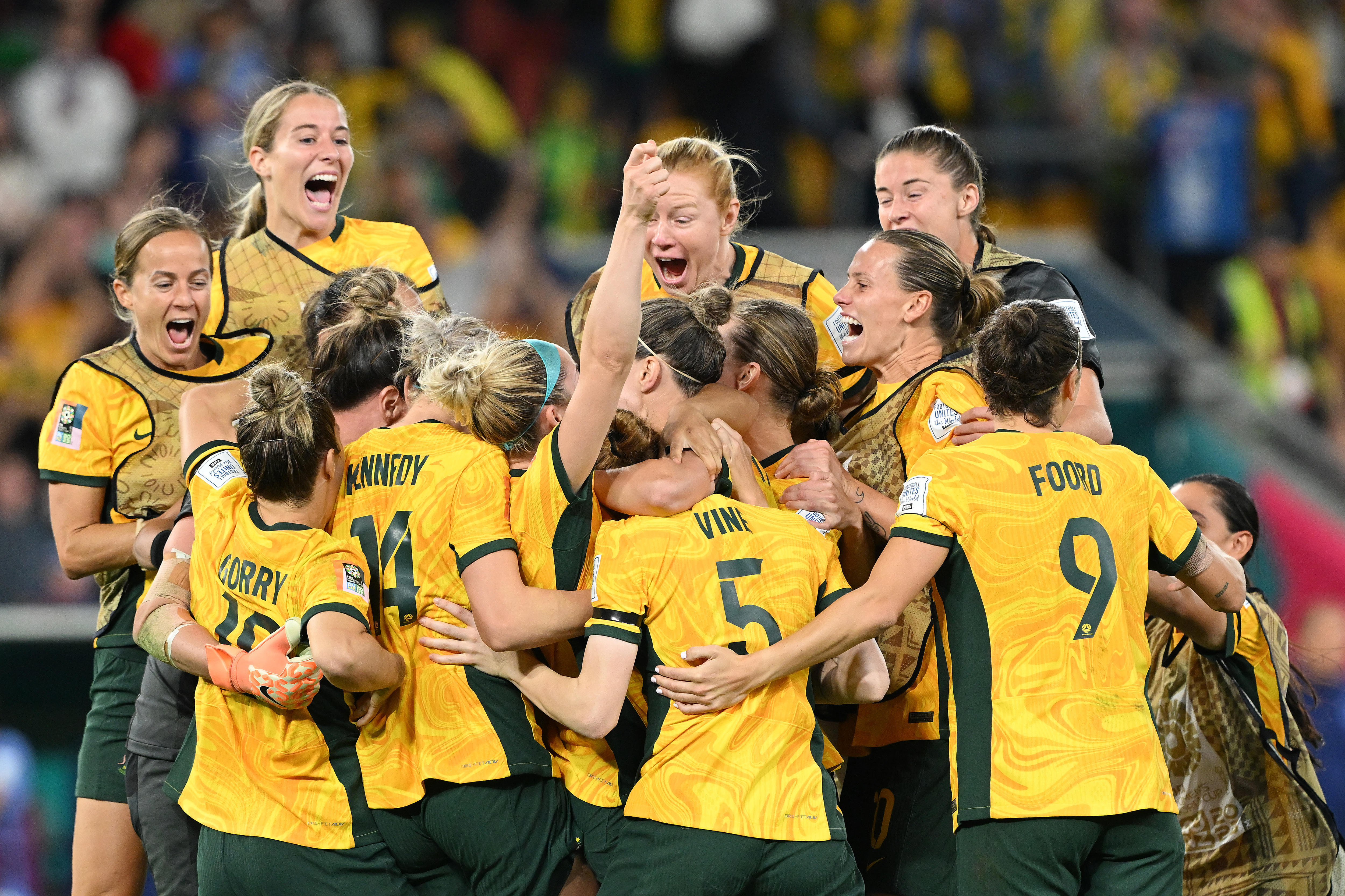 A group of Matildas footballers jump together in delight, celebrating a big win at the Women's World Cup.