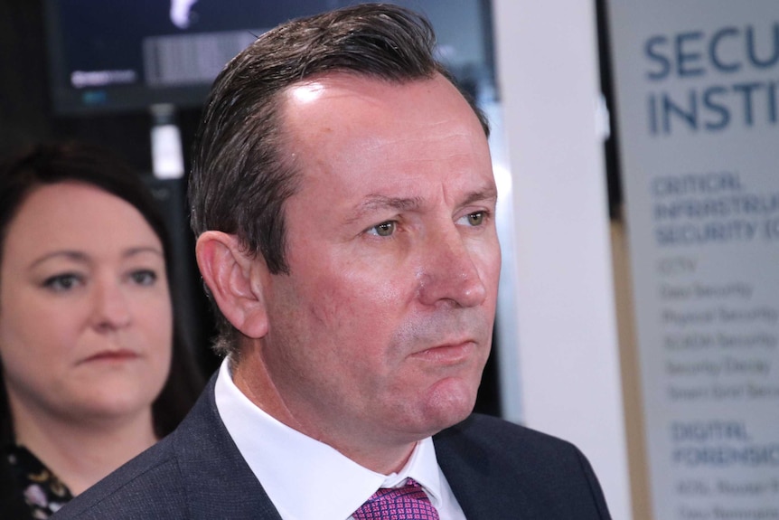 A head and shoulders shot of WA Premier Mark McGowan with Joondalup MP Emily Hamilton in the background.