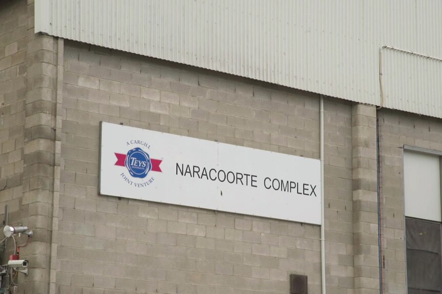 Un cartel en el exterior de un edificio de ladrillo gris que dice 'Teys Australia Naracoorte Complex'.