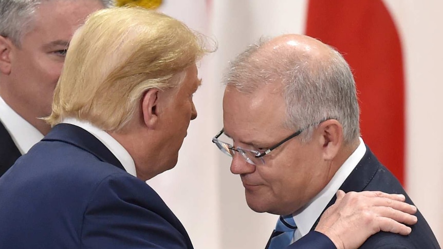 Donald Trump puts his hand on Scott Morrison's shoulder while speaking close to his face