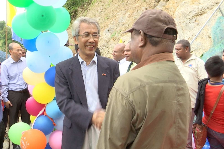 Li Ruiyou shaking hands with Patrick Pruaitch