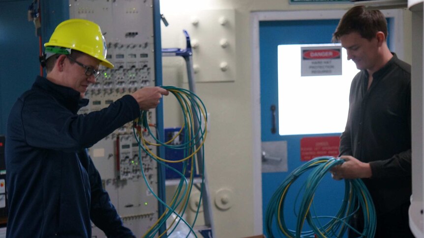 Two researchers with equipment for the alien search inside the Parkes CSIRO Telescope.