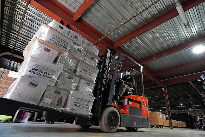 A forklift operator loads absentee ballots for mailing out to voters.