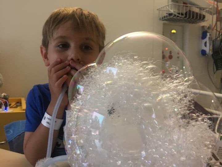 Boy blows bubbles to strengthen lungs