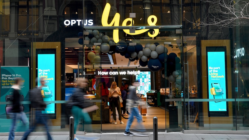 People walk past an Optus store in Sydney.