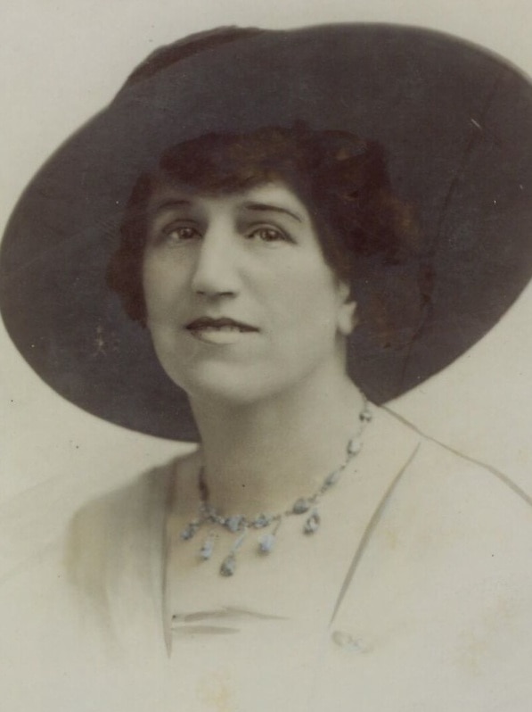 An old photo of Edie Digby who is wearing a jewelled necklace and a large hat.