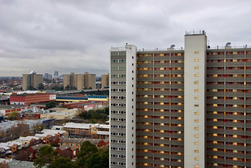 On an overcast day, you view a large post-war modernist public housing tower with others seen on the horizon.