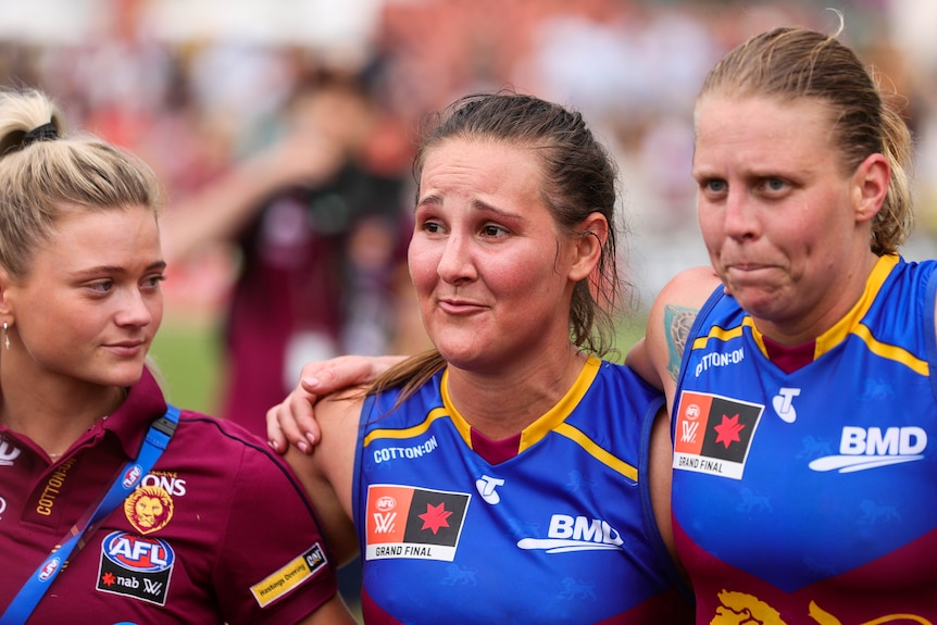 Breanna Koenen is visibly upset while standing in a huddle with her Lions teammates