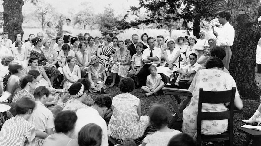 Jiddu Krishnamurti lectures to a crowd of people.