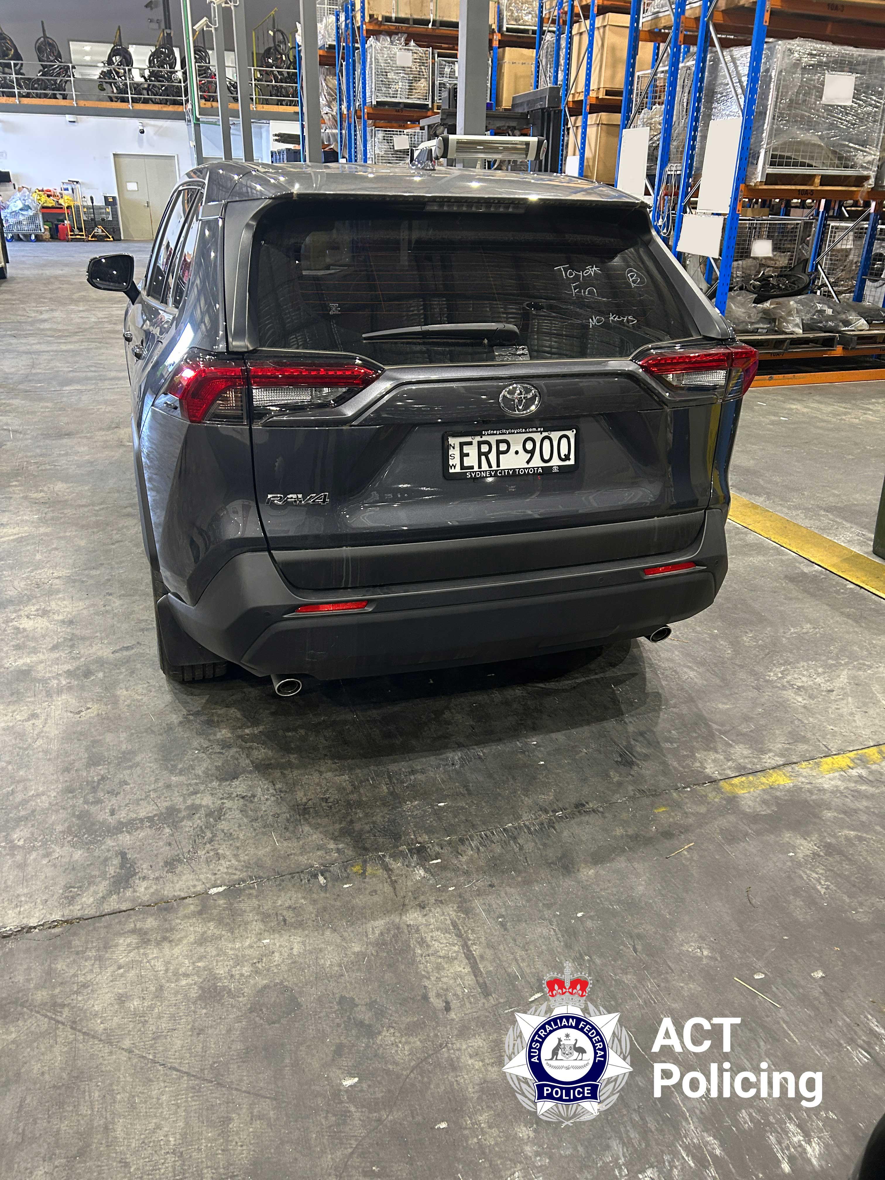 A dark grey Toyota Rav4 from behind.