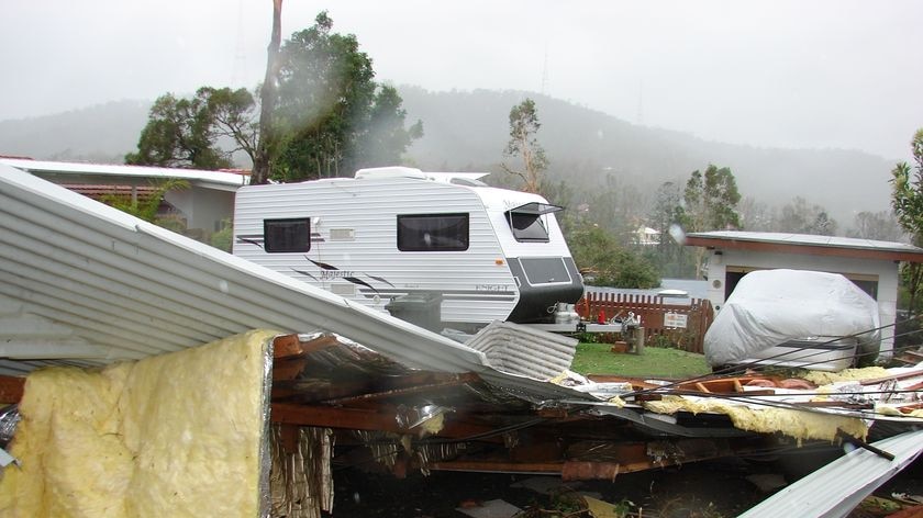 Pic of tree and roof debris, house and caravan, storm damage in Weemala Street in The Gap