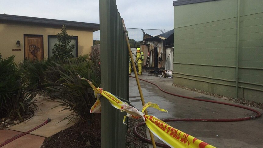 Firemen inspect the damaged shed.