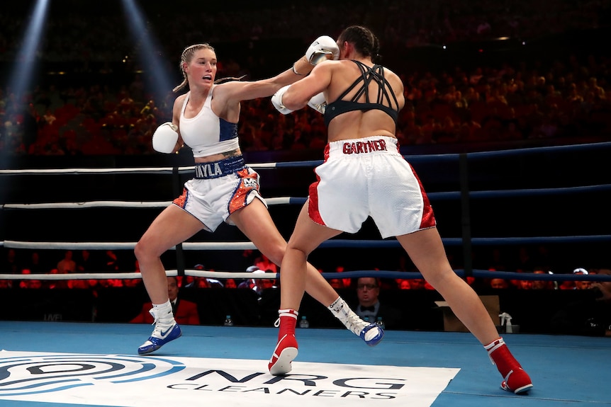 Tayla Harris punches Renee Gartner in a boxing ring.