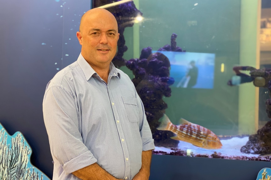 Exmouth Shire acting CEO Matt Bird stands in front of an aquarium