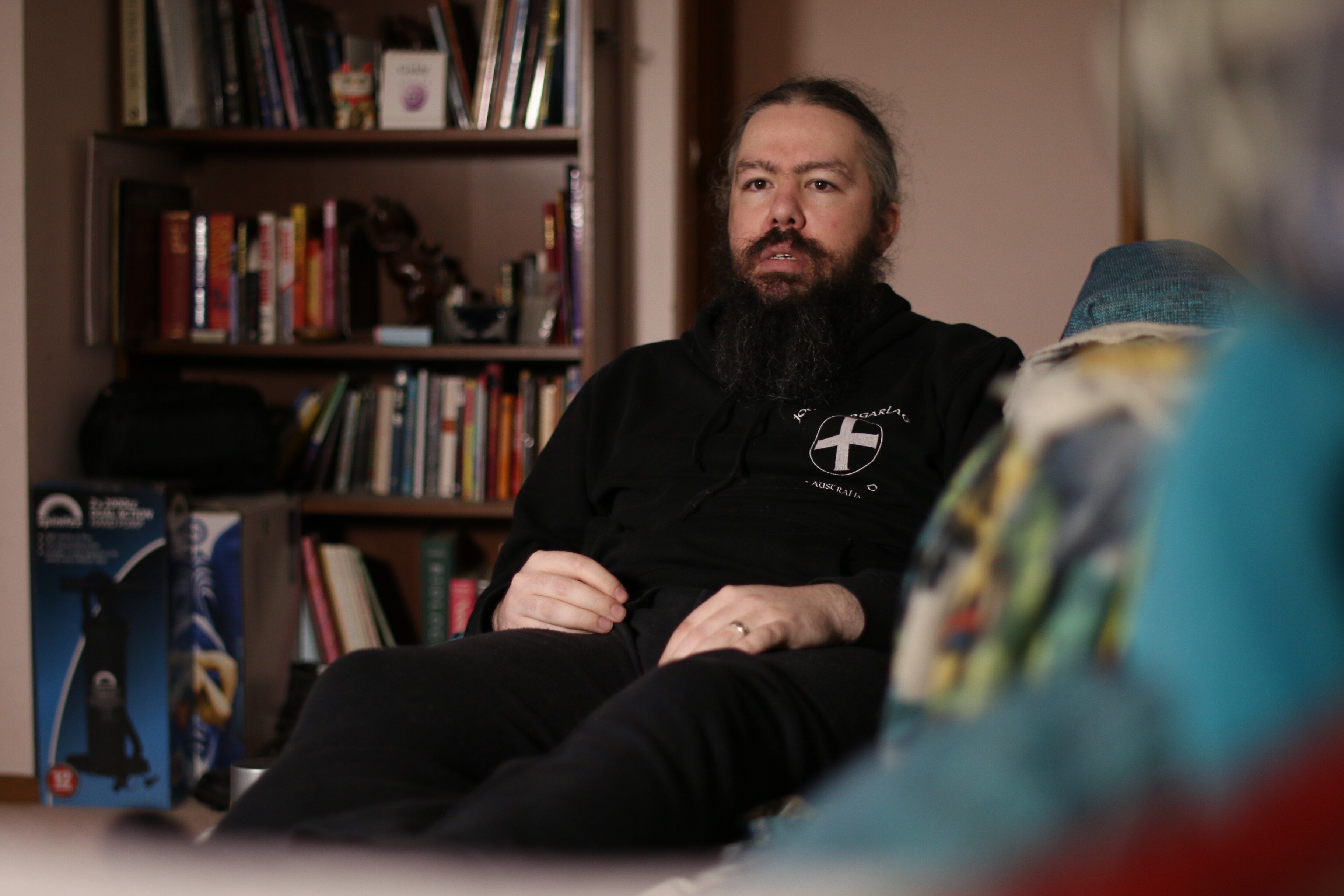 A man with long hair and a long beard sitting on a couch