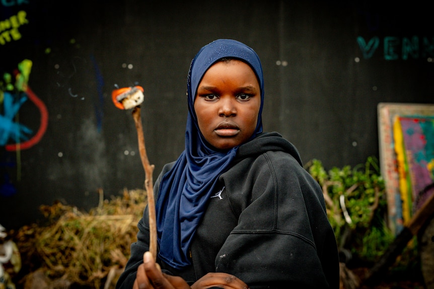 A young girl of African background holding a stick with a toasted marshmallow