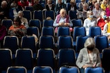Rows of seats with about a third filled with older people