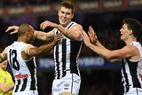 Collingwood's Travis Varcoe, Mason Cox and Brody Mihocek react after Cox scores against Collingwood.