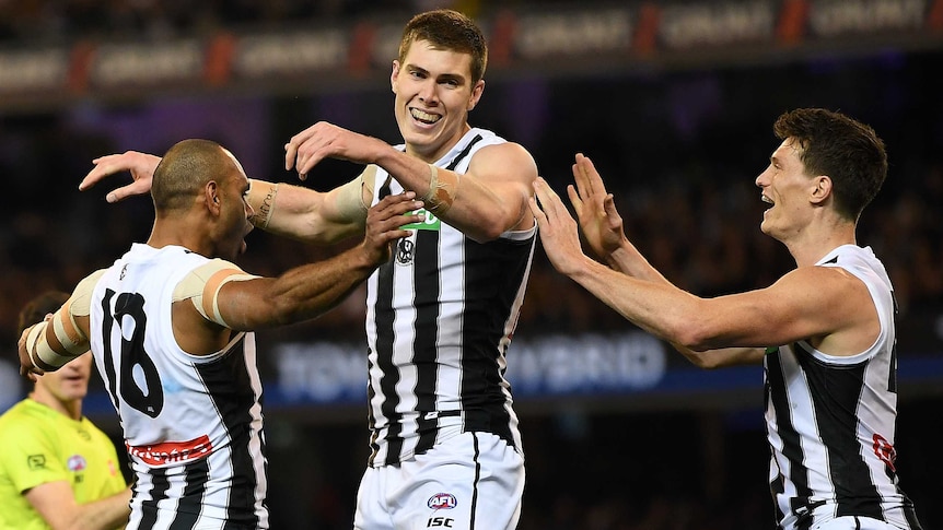 Travis Varcoe, Mason Cox and Brody Mihocek celebrate a Collingwood goal against Richmond