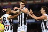 Travis Varcoe, Mason Cox and Brody Mihocek celebrate a Collingwood goal against Richmond