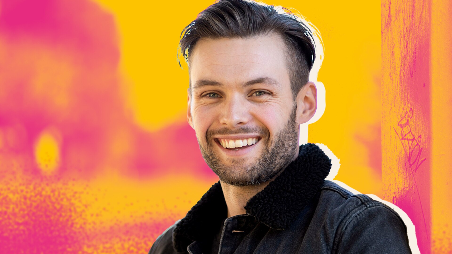 Benjamin Hampton smiling and look at the camera wearing a black jacket with a pink and orange illustrated background