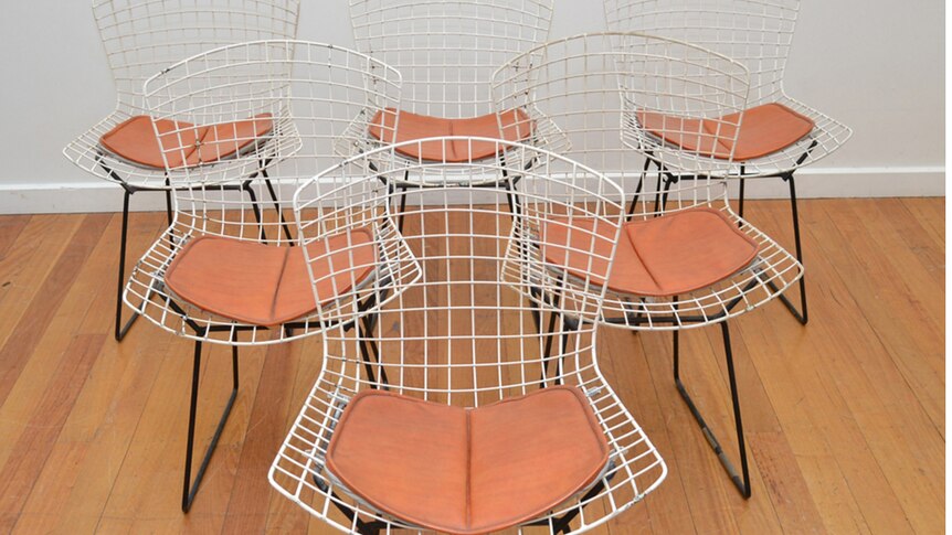 Six wire chairs with orange vinyl seats.