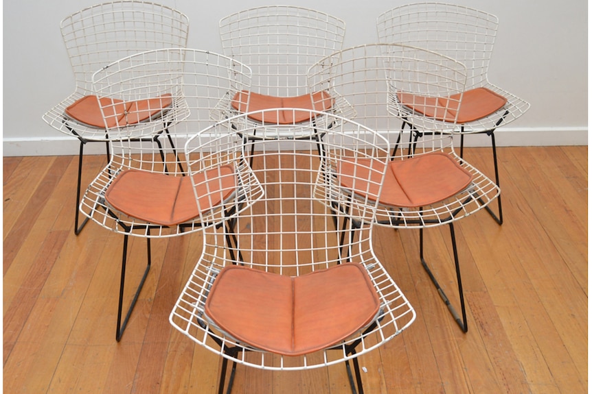 Six wire chairs with orange vinyl seats.