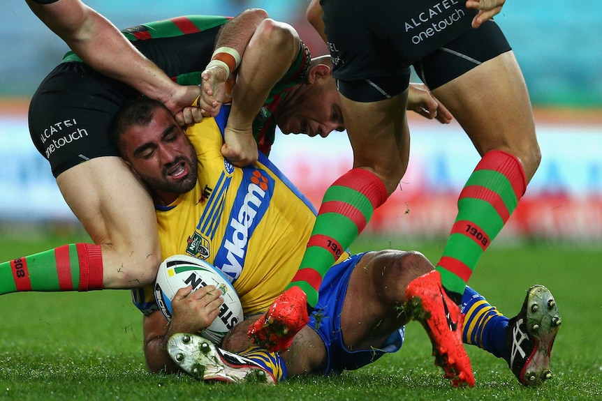 Tim Mannah is tackled by South Sydney Rabbitohs