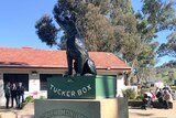 Statue of a dog sitting on a tuckerbox.
