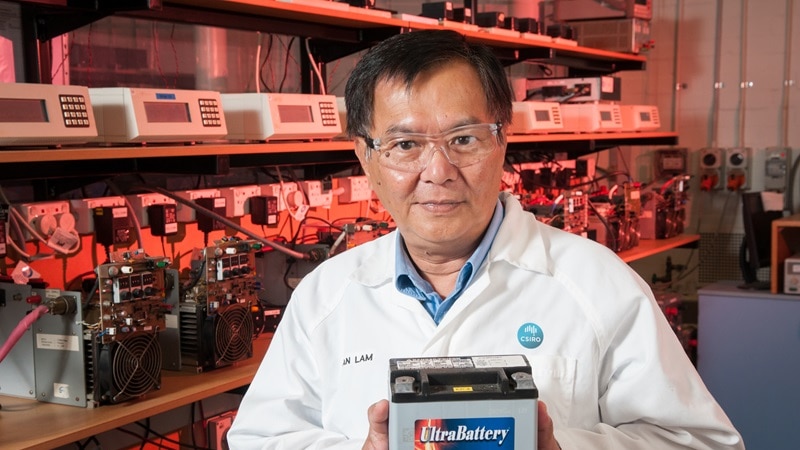 CSIRO scientist Dr Lam Lan in white coat standing up and holding an Ultrabattery