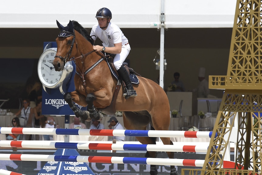 Man jumping hurdle on a horse.