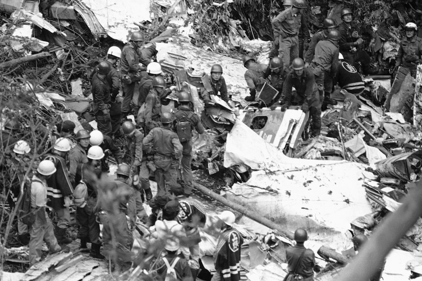 A black and white photo of soldiers at a plane crash site 