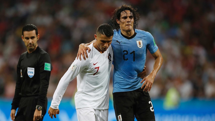 Ronaldo helps Cavani off the field as the referee watches on.