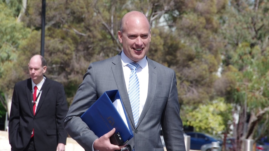 WA Transport Minister Dean Nalder holding a briefcase as he walks into a Cabinet meeting